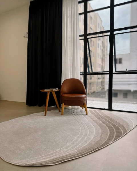 Poltrona Studio Lounge, janelas com iluminação natural e tapete orgânico no chão